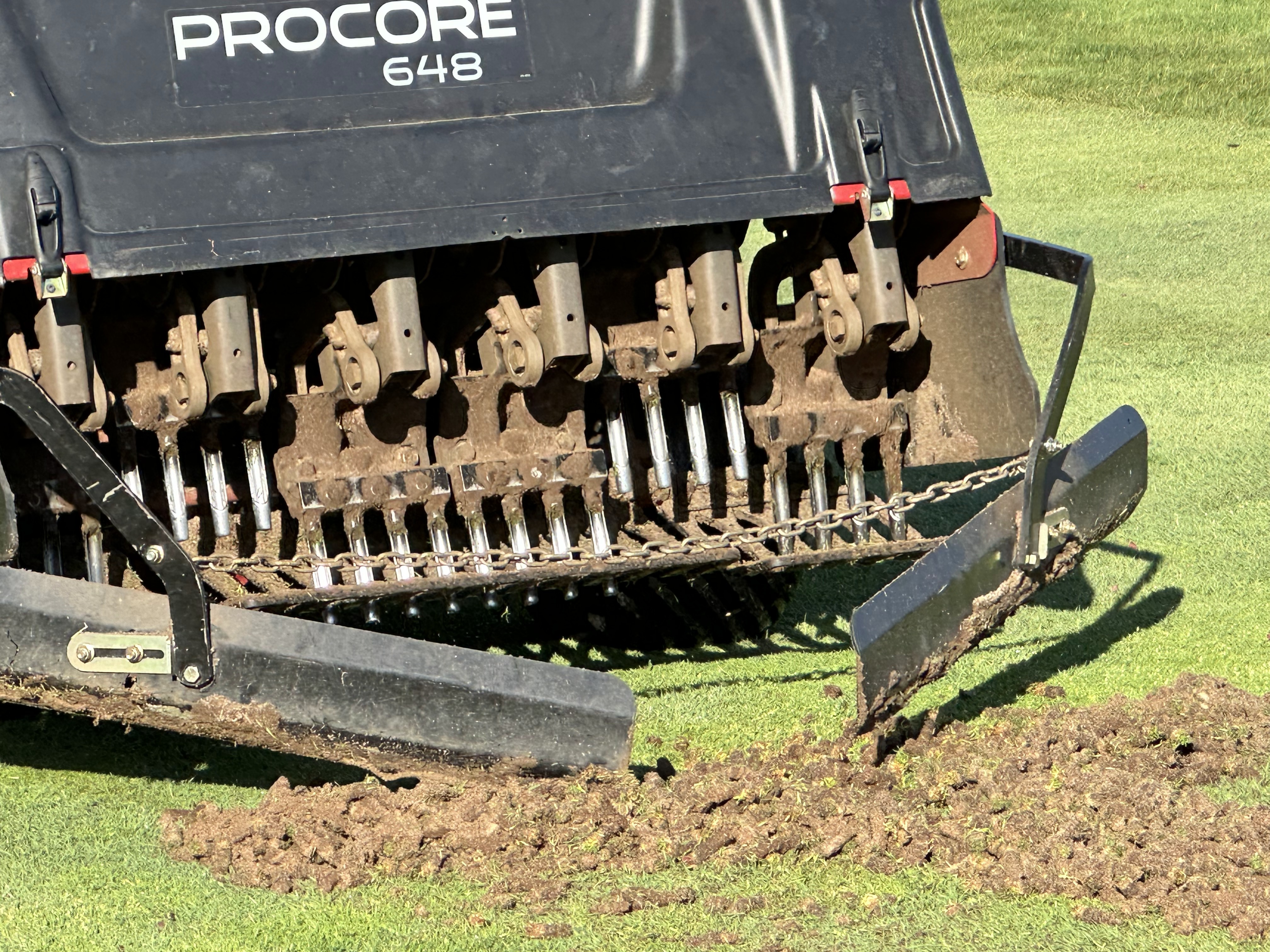 Putting green filled with fresh topdressing sand during aerification.