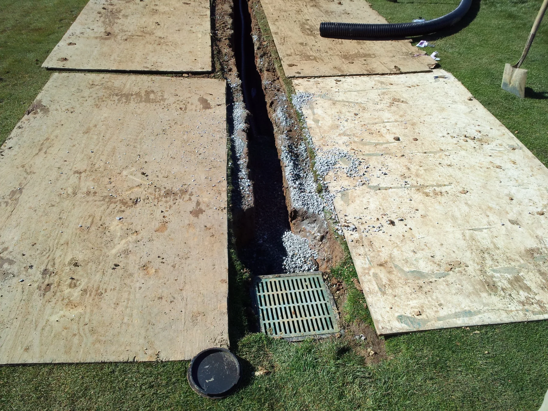 Protected trench leading into a drain grate