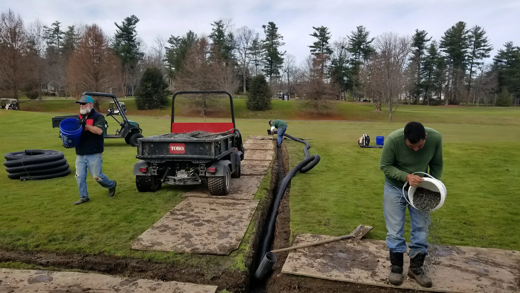 Crew installing drainage with plywood access