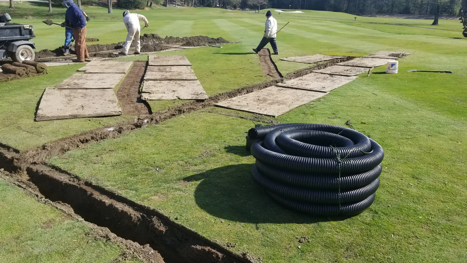 Long plywood route protecting turf during drainage work