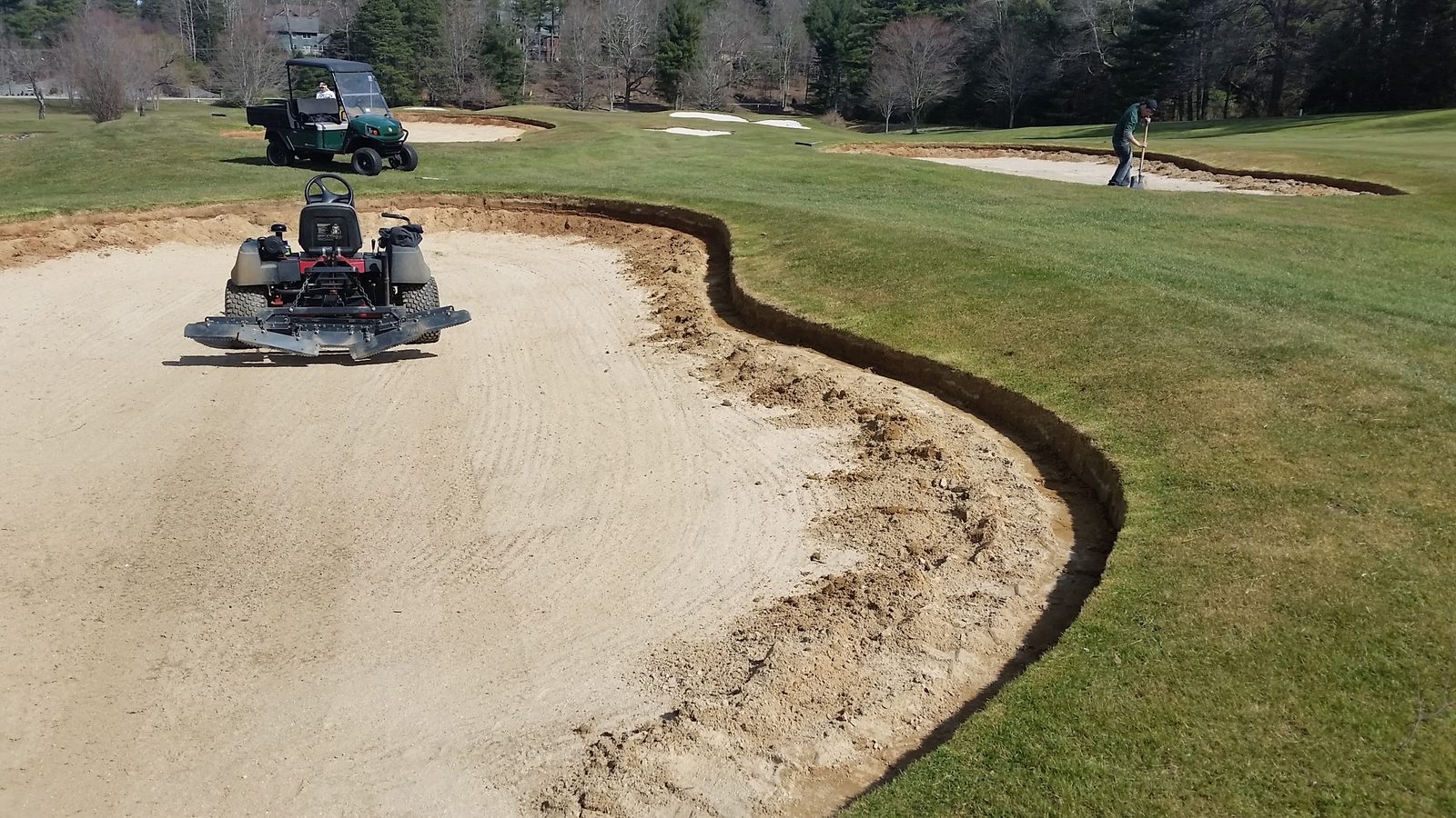 Bunker edge repair and sand work on a golf course