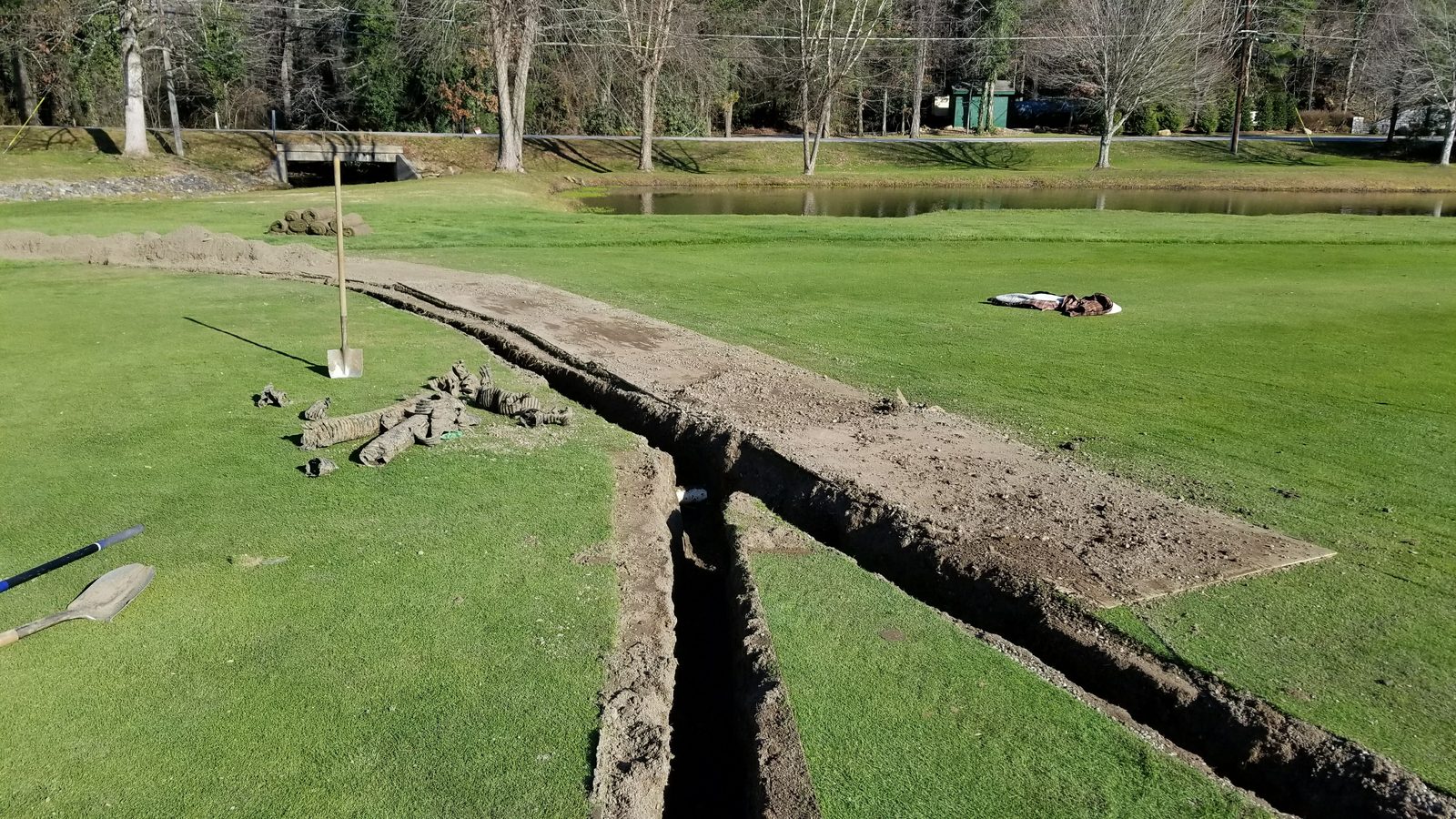 Drainage line cut across maintained turf