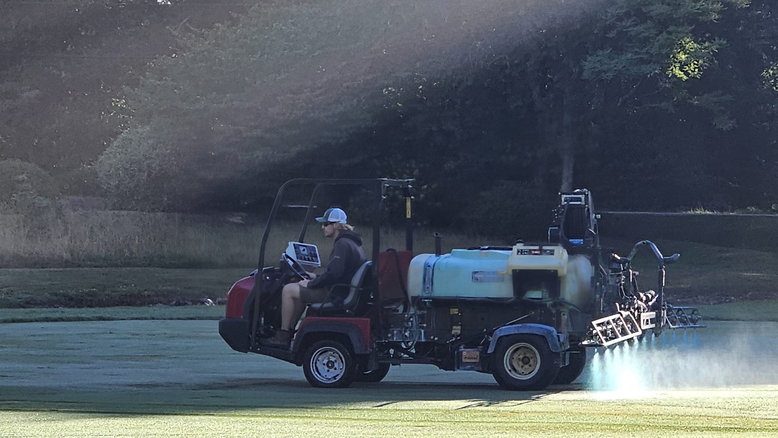 Spray rig applying product across golf course turf